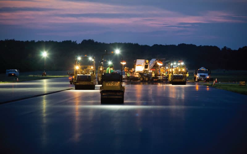 lindy team road rolling and sealcoating during the night with spotlights