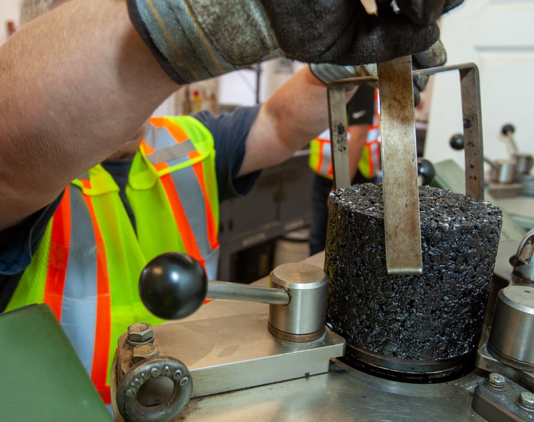 construction worker pulling an asphalt sample