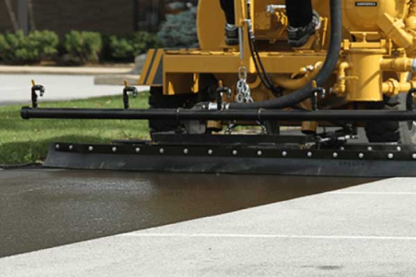 pavement sealer machine sealcoating a parking lot